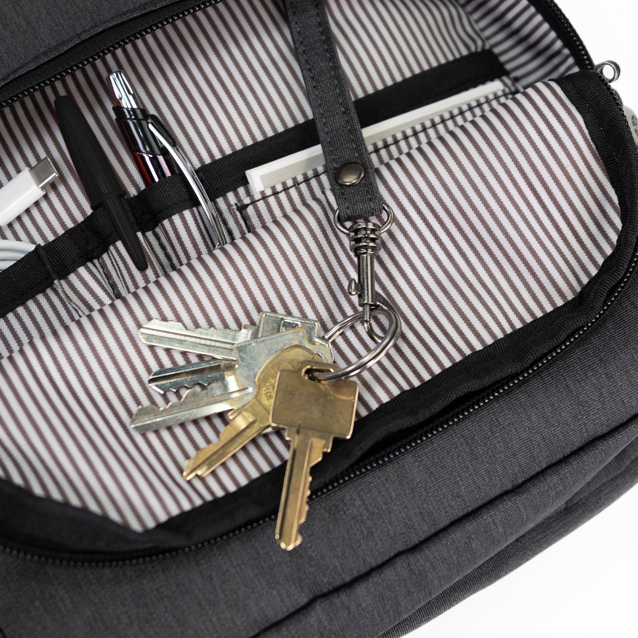 PKG Robson 12L Cross-Body Laptop Bag detailed view of front pocket with built in organization and key ring hook