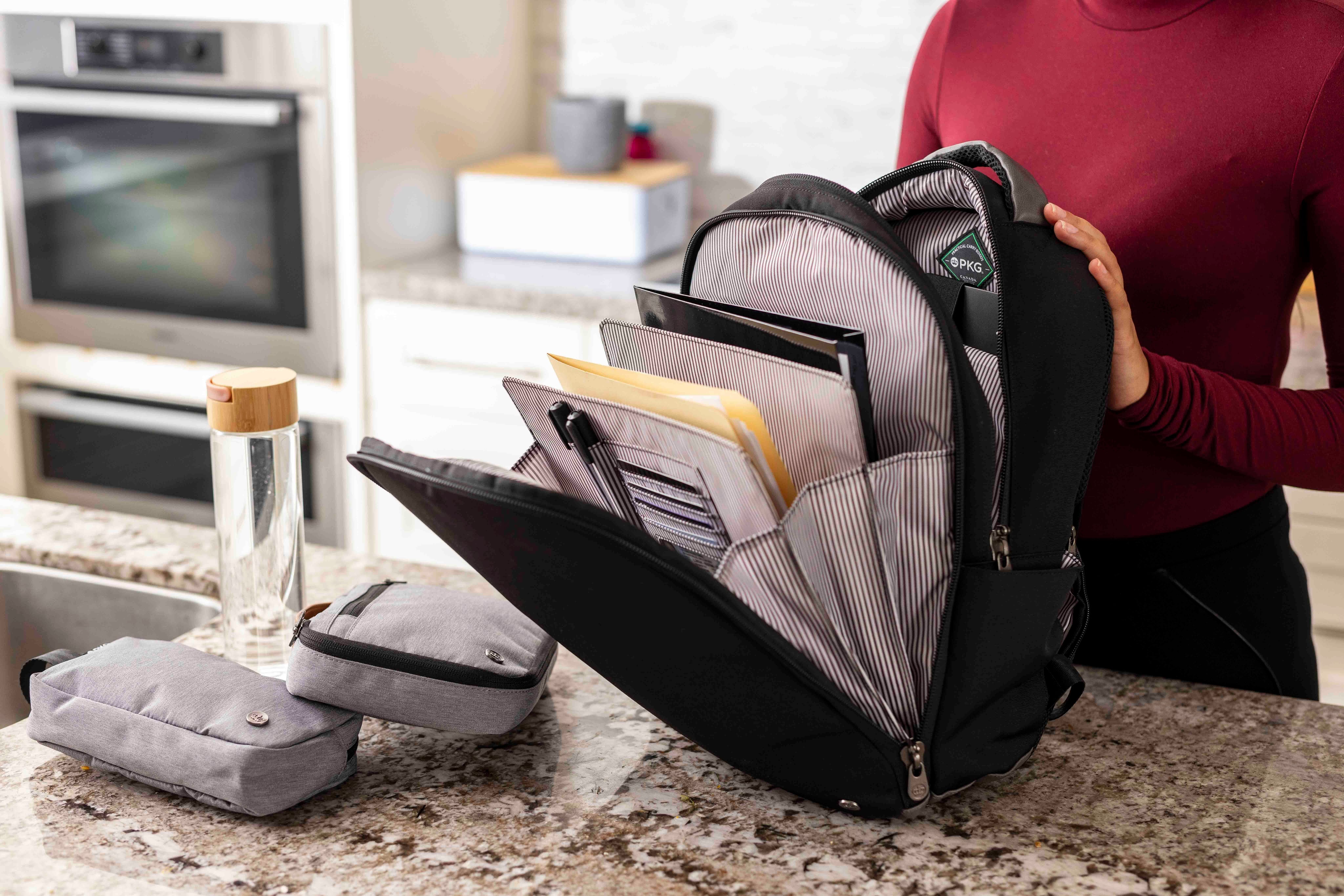 PKG Durham Commuter 17L recycled backpack (black) showing documents and office supplies being organized
