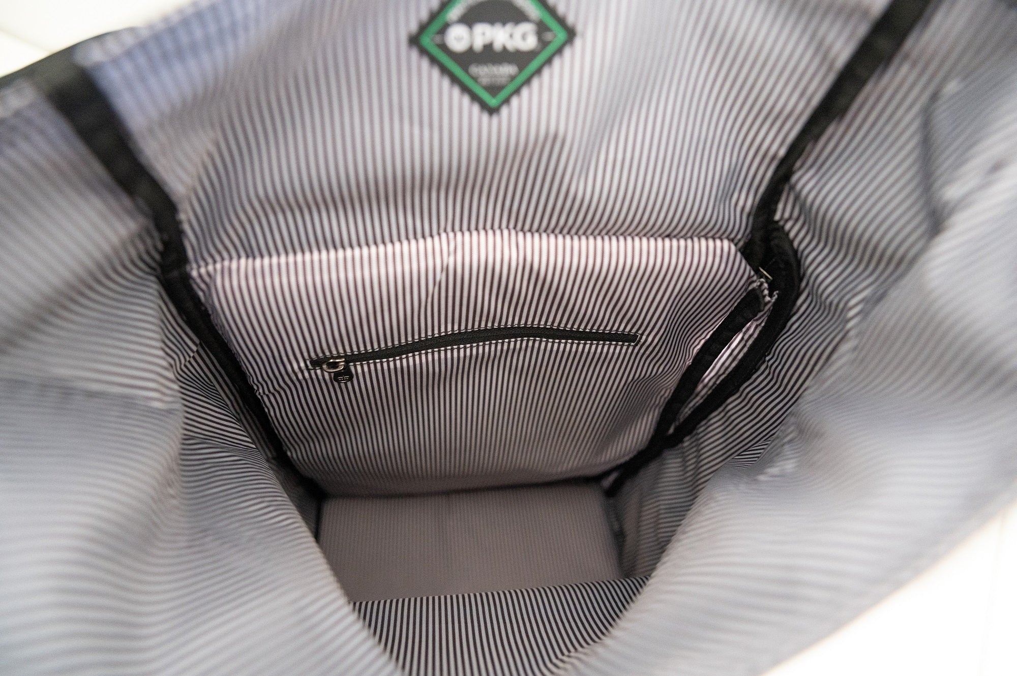Dawson 28L Roll-Top recycled backpack (navy) showing inside main compartment with inner pockets