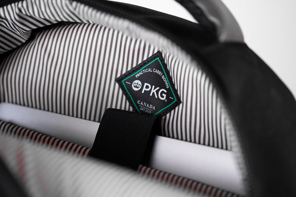 PKG Durham Commuter 17L recycled backpack (black) showing dedicated laptop pocket with secure velcro strap