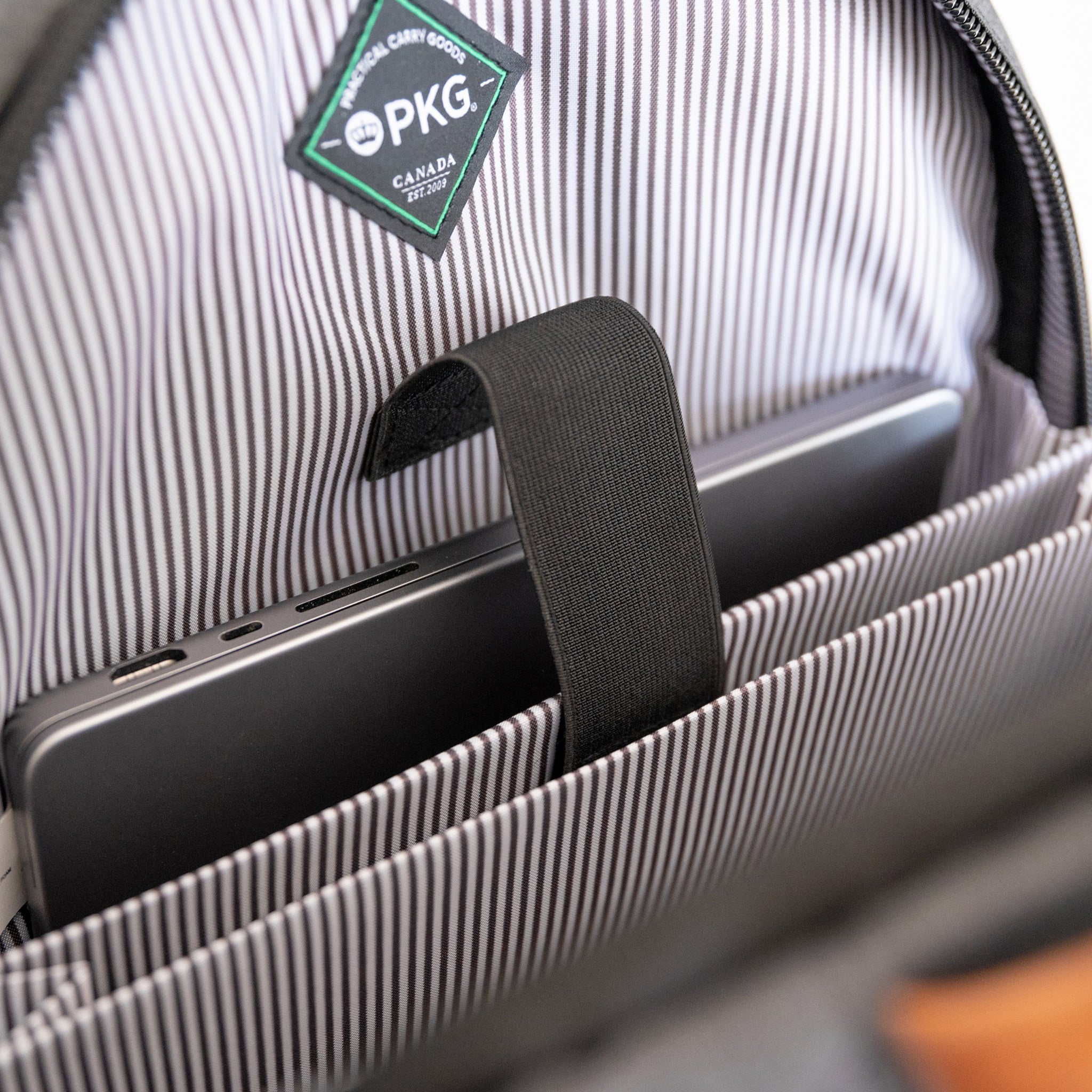 Durham Outpost recycled commuter backpack (ginger root) open, showing dedicated laptop pocket with secure velcro strap