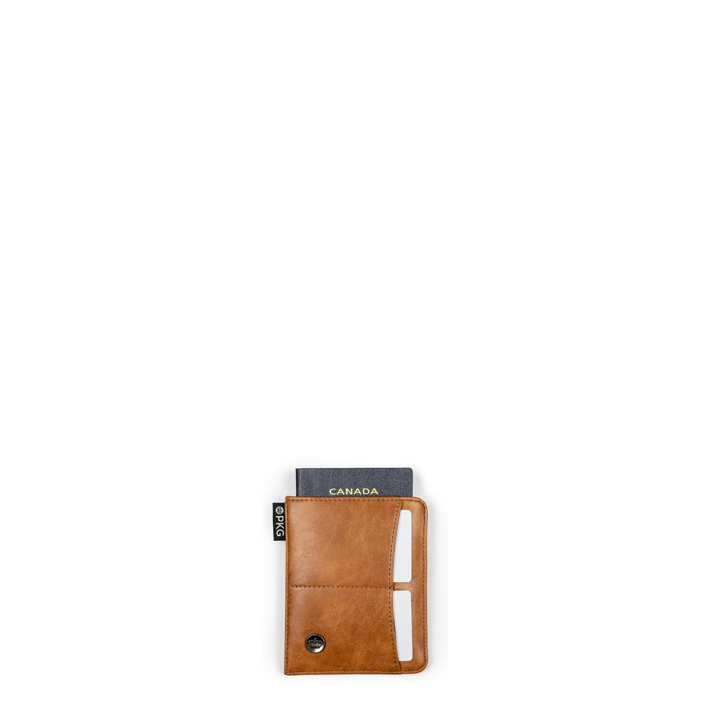 PKG Perry RFID Passport Wallet (tan) – your go-to for secure travel organization. Crafted from durable vegan leather, this wallet accommodates 4-6 cards, your passport, boarding pass, and cash