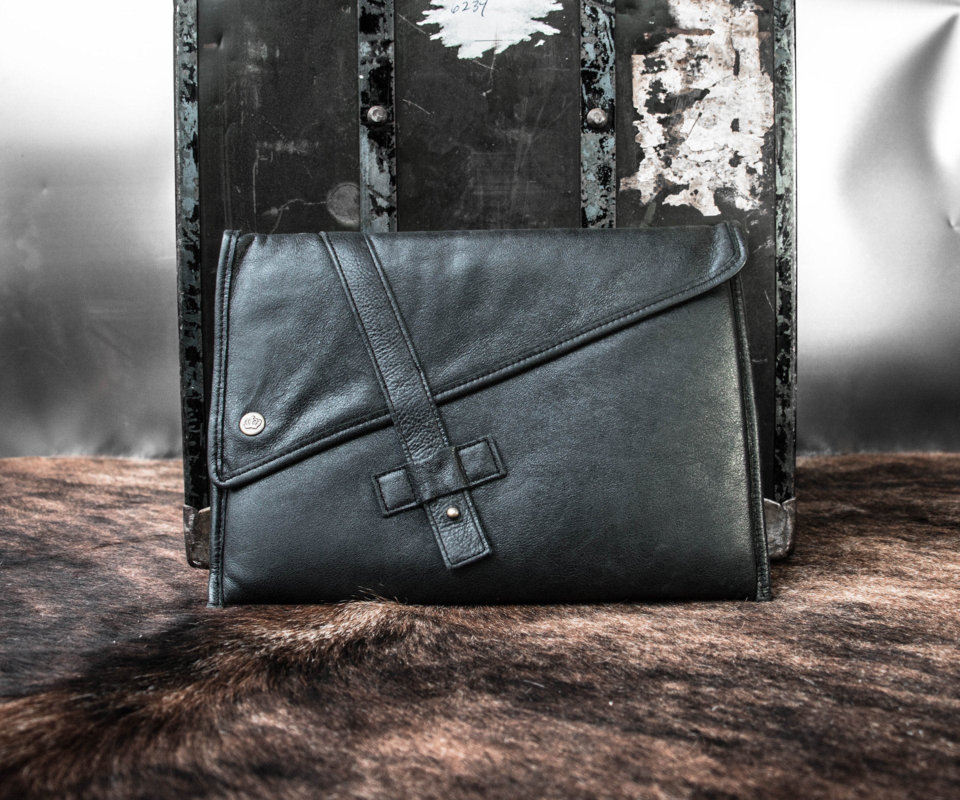 PKG Slim Leather Sleeve 13" (black) resting on luggage