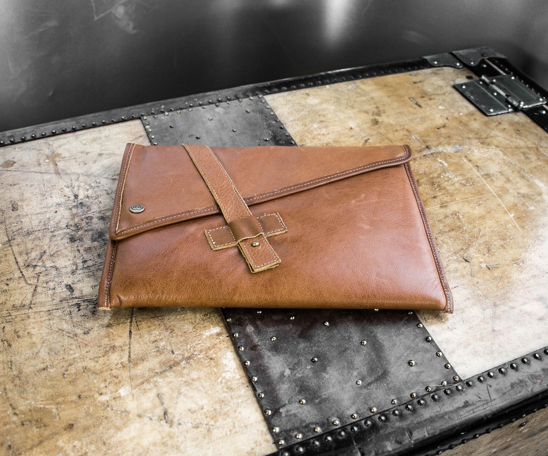 PKG Slim Leather Sleeve 13" (tan) resting on luggage