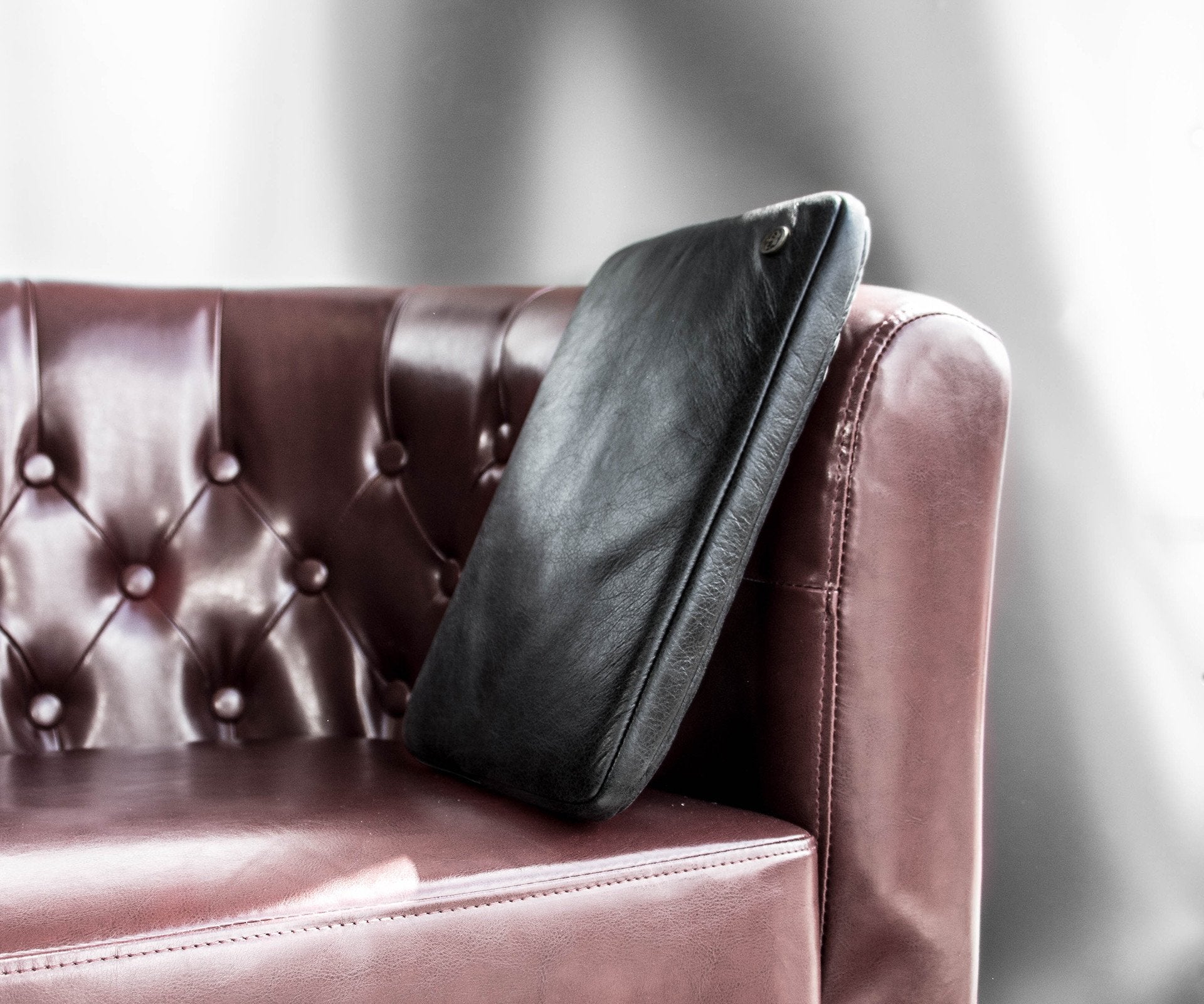 PKG Skinny Leather Sleeve 15" (black) resting on couch