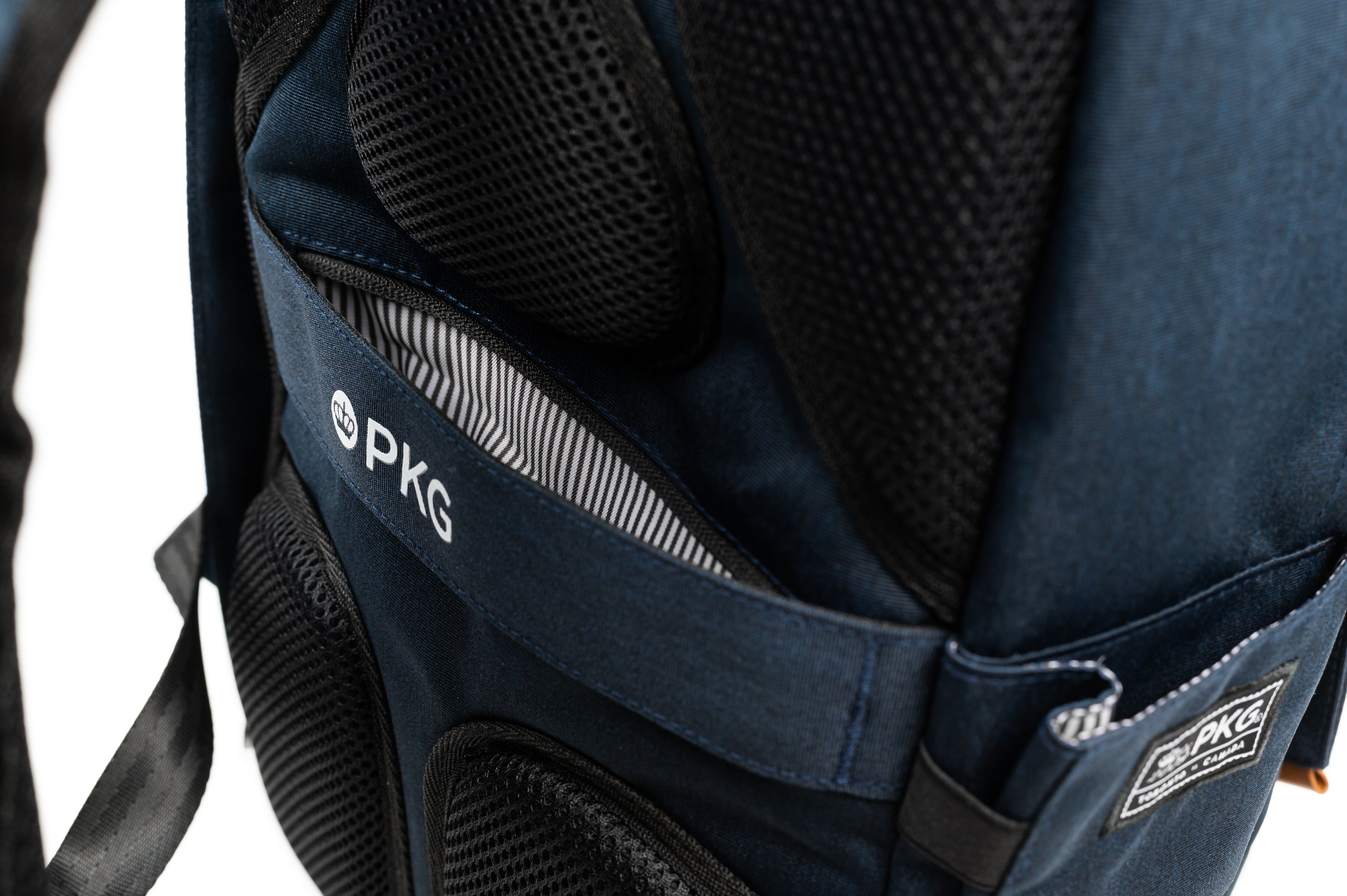 PKG Rosseau 19L Recycled Backpack Tote (navy) detailed back view showing breathable padding and hidden pocket behind trolley strap for valuables