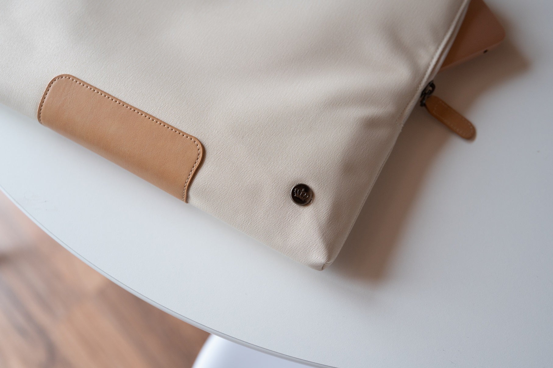PKG Slouch sleeve (sand) resting on table