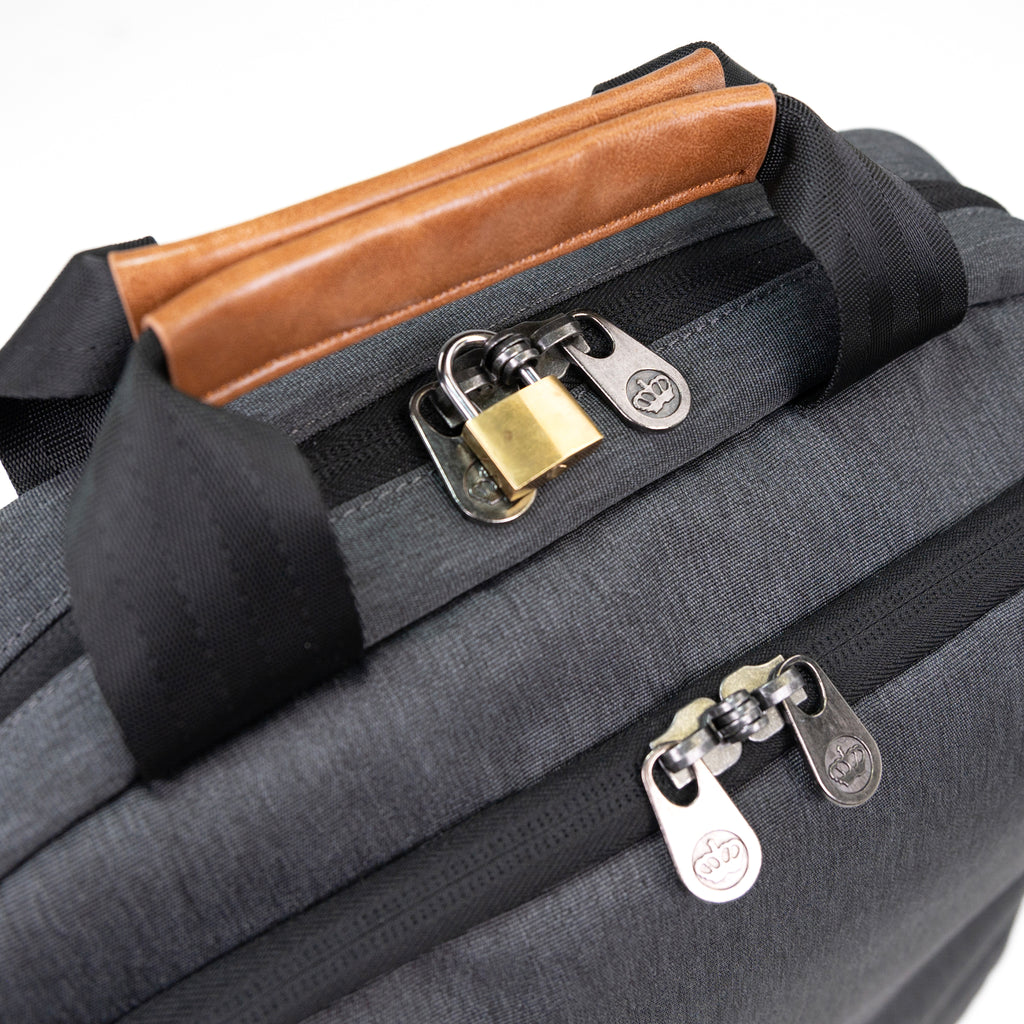 PKG Riverdale 11L Messenger Bag detailed top view of lockable zippers connected with padlock, and magnetic vegan leather handles