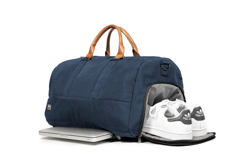 PKG Bishop 42L recycled duffle bag (navy) showing both the dedicated shoe compartment and padded laptop compartment