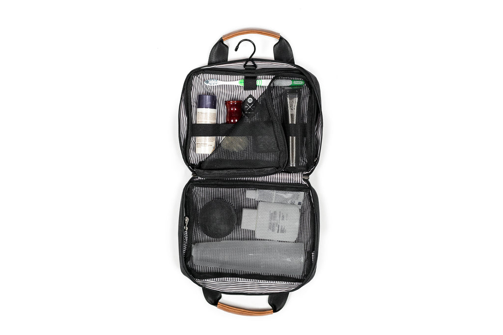 PKG Simcoe accessory bag (black) open bag view showing toiletry products organized neatly in various compartments