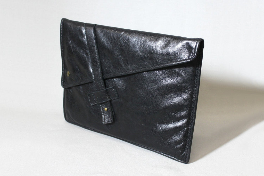 PKG Slim Leather Sleeve 13" (black). Crafted from distressed top grain leather, this slim laptop sleeve features antique brass hardware, a secure collar tab closure, and a custom snap for added security. Carry it solo or slip into another bag effortlessly