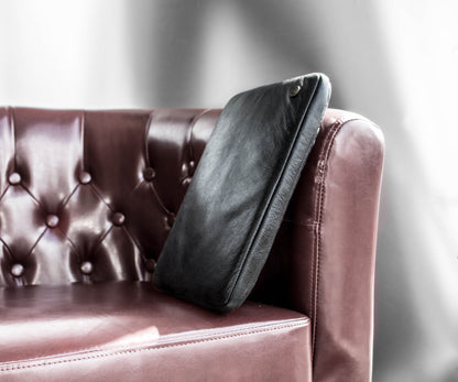 PKG Skinny Leather Sleeve 15" (black) resting on couch