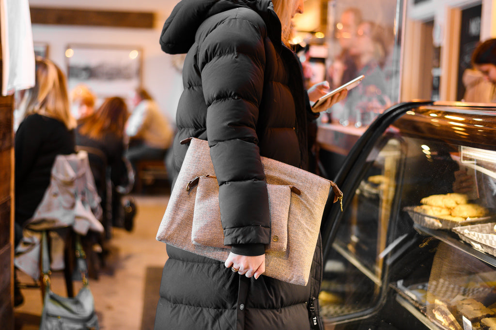 Woman carrying PKG Slouch sleeve (tweed) in a cafe