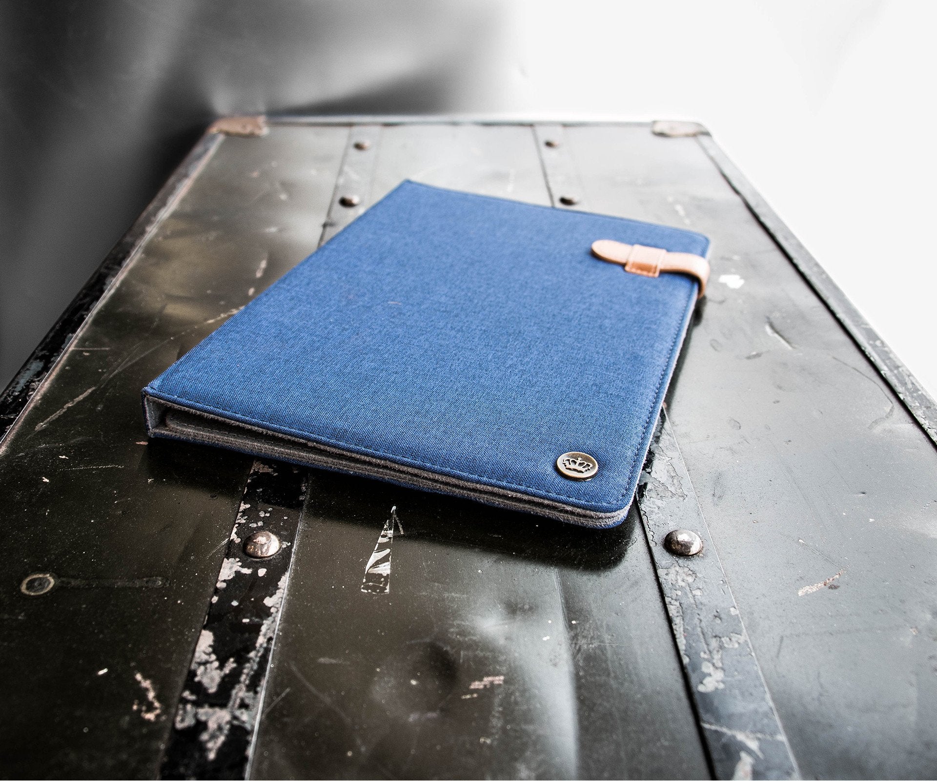 Universal Tablet Folio (blue) resting on metal box