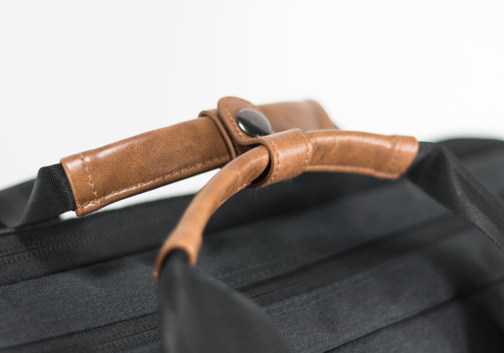 PKG Trenton 31L Messenger Bag (dark grey) detailed view of vegan leather handles secured with clip
